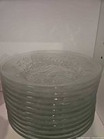 Stack of twelve clear/frosted glass plates with ribbed edges