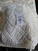 Stack of crocheted cotton linens showing floral mesh pattern and color range
