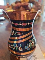 side view showing floral cloisonné design and copper bands
