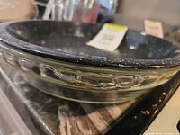Side view showing nested speckled enamel pan and clear glass dish