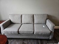 Front view of three-seat sofa showing full design and cushions