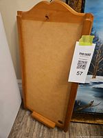 Front view of light wood calendar holder showing MDF backing and bottom ledge