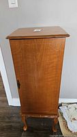 Front view of tall oak veneer jewelry armoire on cabriole legs