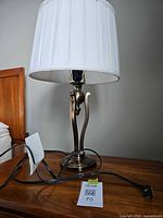 Lamp on bedside table showing full form, shade, cord and finial