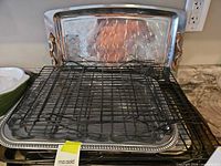 Stacked baking sheets, cooling racks on top, decorative tray behind