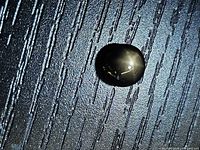 Top view of black star sapphire showing star effect