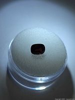 Cushion-cut red spinel displayed in gem jar, top view