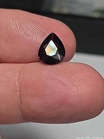 Pear-cut deep purple spinel on fingertip
