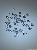 Group of small round faceted tanzanites in mixed colors under light