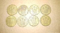Reverse view of all eight threepence coins showing thrift plant design and dates