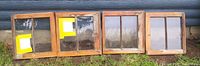 Four raw wood sash windows showing divided lites