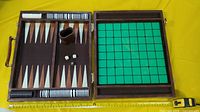 open case showing backgammon and reversi boards, disks, dice cup, dice, ruler for scale