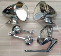 Two bullet-style chrome mirrors, two chrome window crank handles, one round chrome mirror with pedestal base