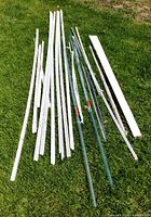 Group of drywall corner beads, curtain rods, shelving standards, blind laid on grass