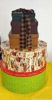 Stack of three rectangular boxes on two round Christmas boxes