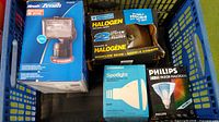 Four boxed halogen lighting items inside blue crate