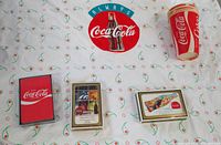 Dish towel laid flat with three playing card decks and Coca-Cola paper cup