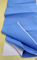 Folded blue canvas sheet showing white backing