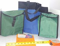 Front view showing two green lunch bags, blue tote and packaged orange mesh bag with measuring tape for scale