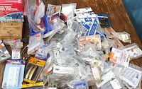 Overview of assorted packaged hardware spread on table