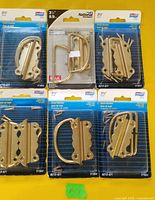 Six sealed National Hardware blister packs of brass chest handles