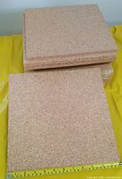 Stack of cork tiles with tape measure showing 12-inch side