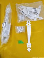 Full gate hardware kit laid out: spring closer, strap handle, hinge bag, screw bag