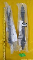Both gate springs in sealed plastic next to measuring tape