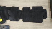 Top view of two overlapped black carpet floor mats