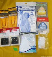 Group shot of all PPE and tools including coverall, gloves, face mask, scrapers, blades, pole sander head and sanding block