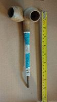 Full view of pipe beside ruler showing length and dual clay bowls