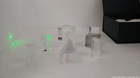 eight clear glass prisms various shapes on white surface