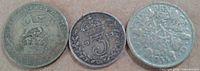 Reverse sides of three coins with denominations and dates