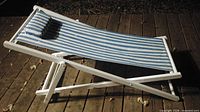 Blue and white striped canvas sling chair on white wooden frame showing overall design and condition