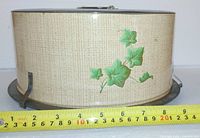 Side view showing ivy motif, measuring tape indicates diameter