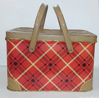 Front view of tin picnic basket showing plaid design and handles