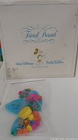 Outer box lid with Trivial Pursuit Walt Disney Family Edition graphics, plastic bag of colorful playing pieces