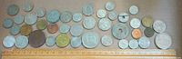 Full layout of entire group of coins above ruler for scale