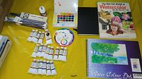 Full lot showing paints, palette, books, charcoal, brushes, colour wheel, paper