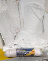 Stack of white flannelette sheets alongside packaged roll of microfiber polishing towels