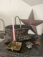 Wicker basket, brass chamberstick, large barn star, mirrored hook visible on countertop