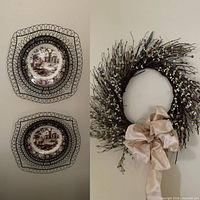 Front view showing both brown transferware plates in black metal hangers and berry wreath with beige bow