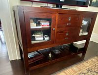 Front view showing glass doors, drawers, lower shelf