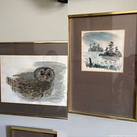 Side-by-side view of both framed paintings: owl and waterscape