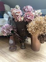 Group shot of all five metal vessels with artificial flowers and bells