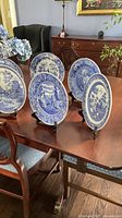 Front view of six blue and white Spode Rome plates on tabletop