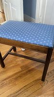 Full view of bench showing upholstered top and wood frame