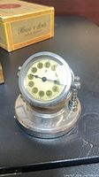 Front and side view of silver-plated German desk alarm clock on stand