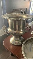 Ornate twin-handled footed urn on tabletop