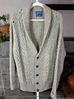 Front view of cardigan on hanger showing overall style and buttons